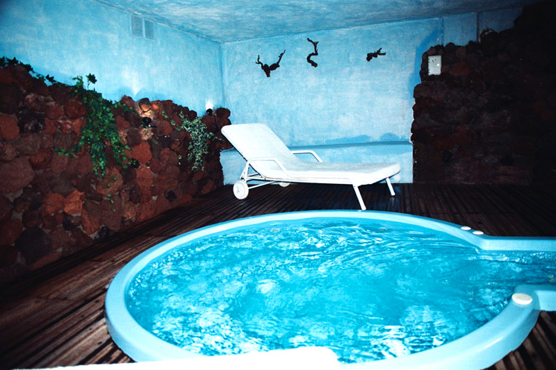 whirlpool im Liebevoll gestalteten Poolbereich mit Holzboden und Lavastein